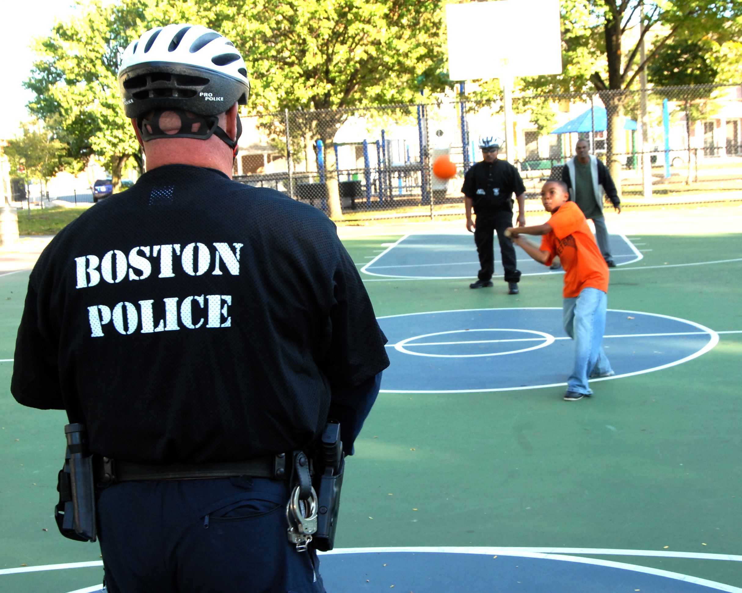 Boston Police officers play basketball with children