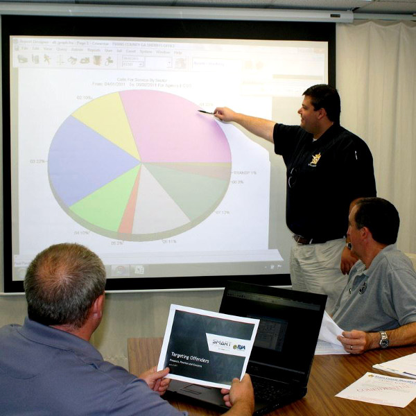 Evans County Police officers watch a presentation with a chart