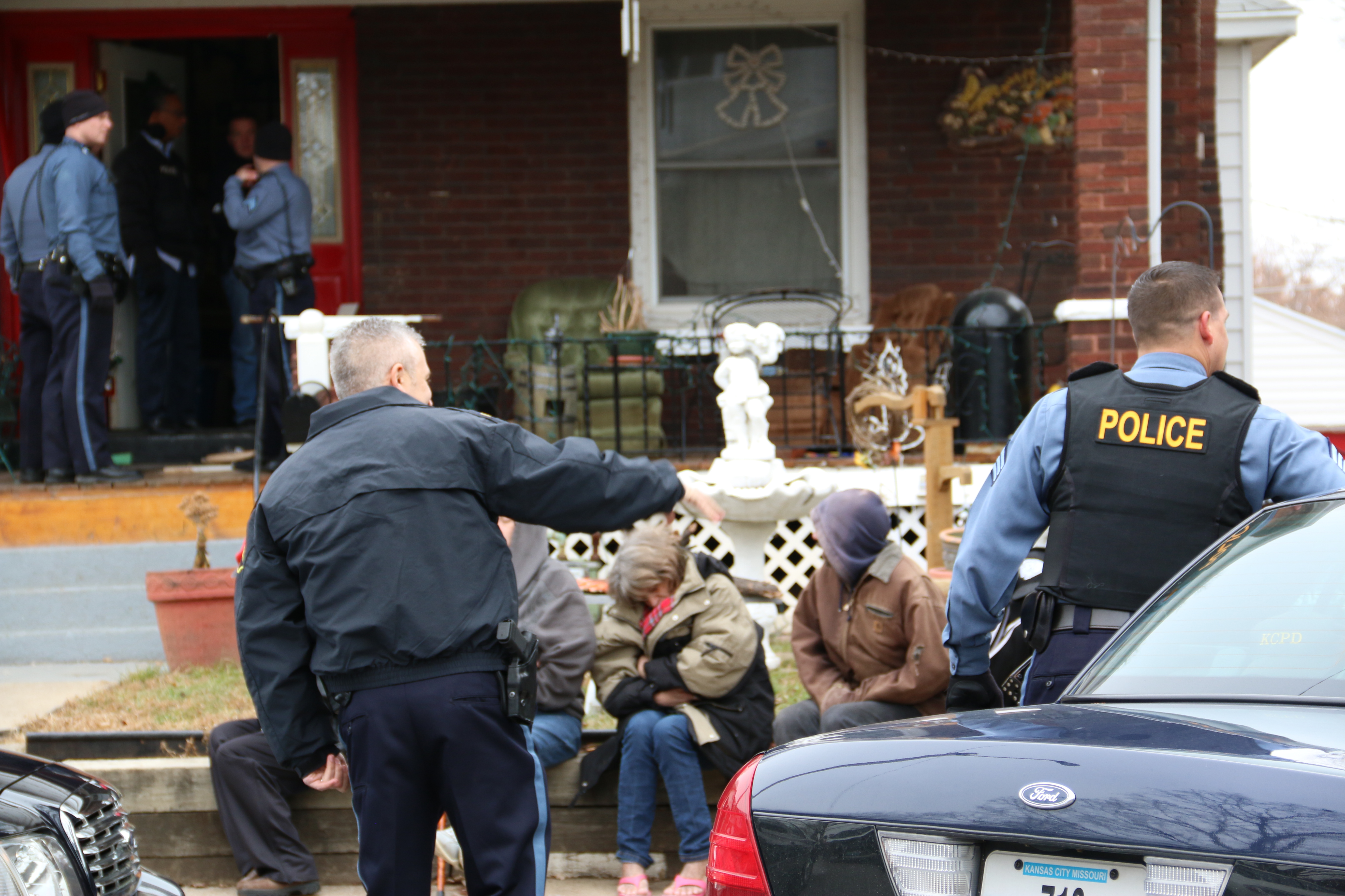 Kansas City Police officers stand outside house